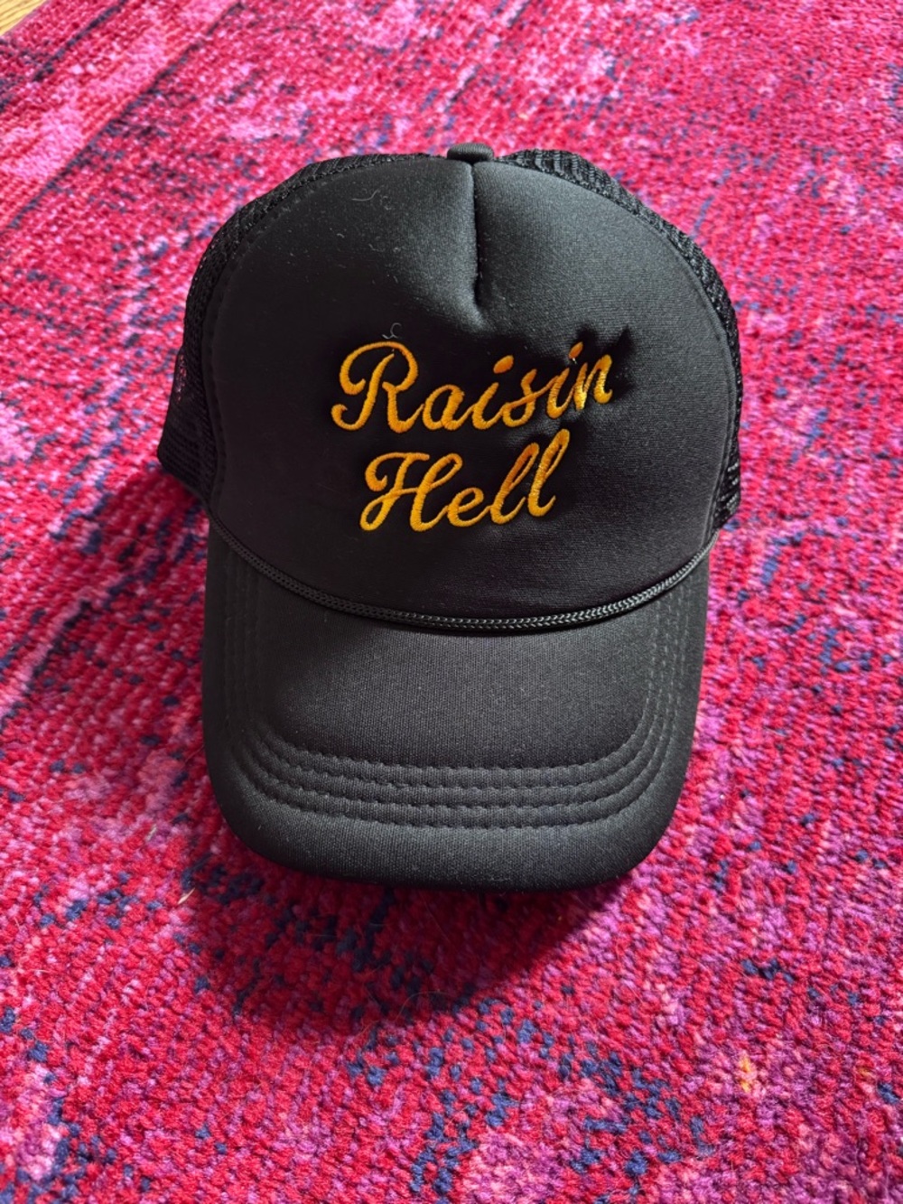 Raisin Hell Embroidered Trucker Hat - Black with Gold Script
